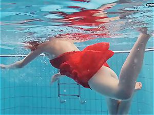 red clad teenager swimming with her eyes opened