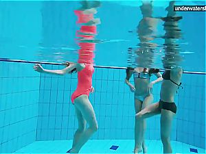 three naked women have fun underwater